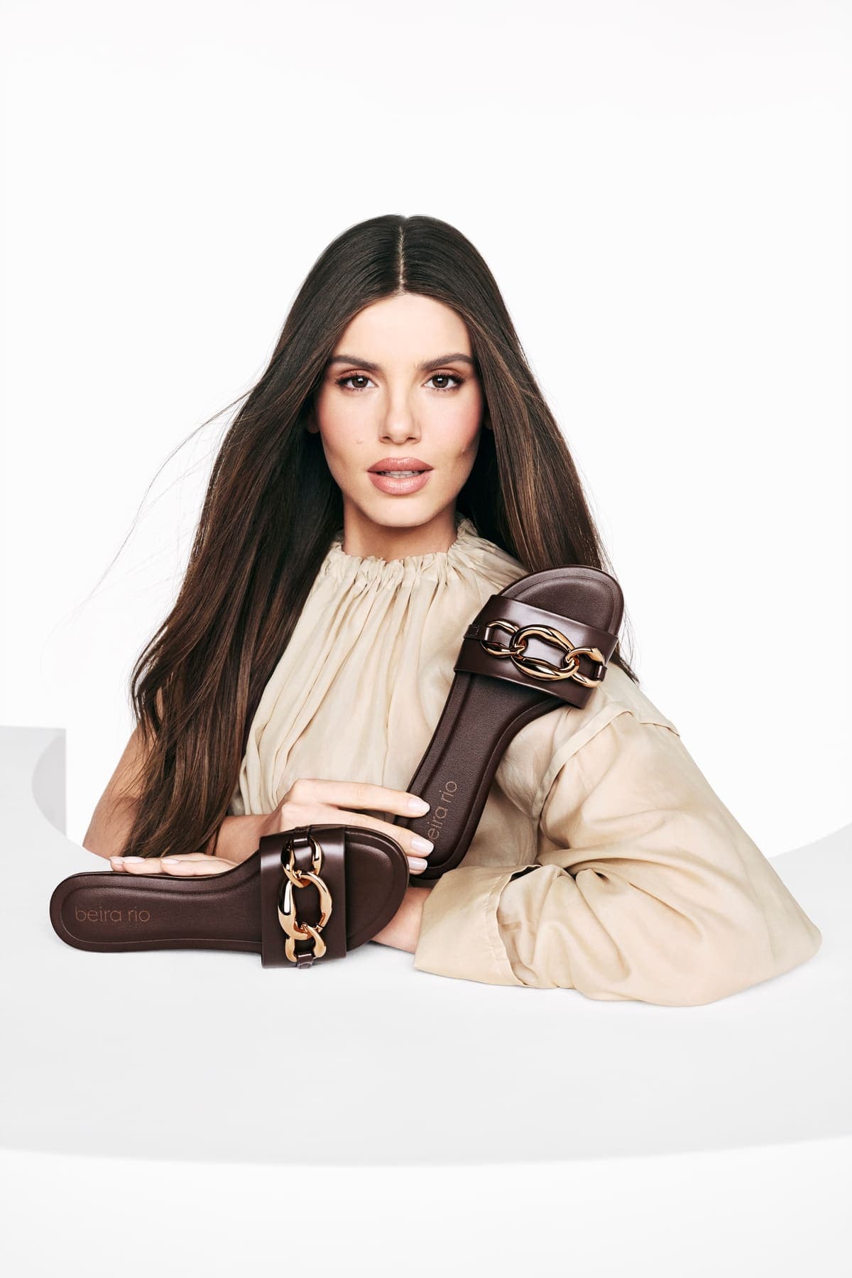 Beira Rio model holding brown sandals